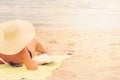 Alikanas, Zakynthos Island, Greece Ã¢â¬â September 28, 2017:Beautiful woman with hat enjoying sun and good book on beautiful beach